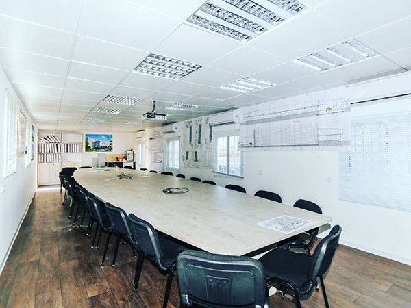 שולחן ארוך בתוך משרד המייצג דוגמה של משרד נייד מטעם חברת שדה